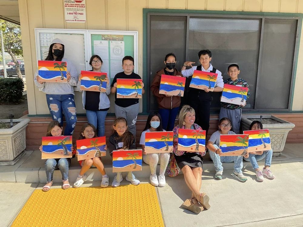 students holding up paintings