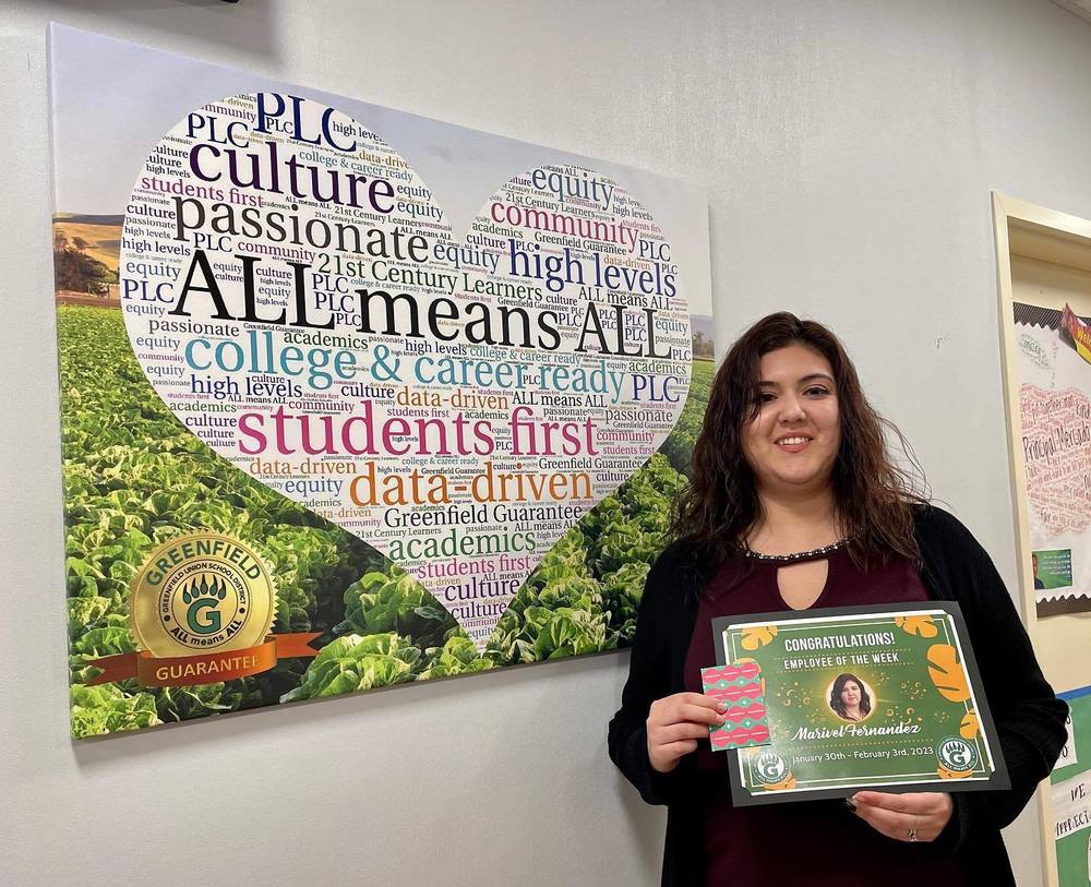 Marivel Fernandez taking a picture with her certificate